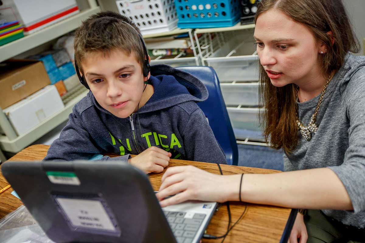 Teacher working with student on computer