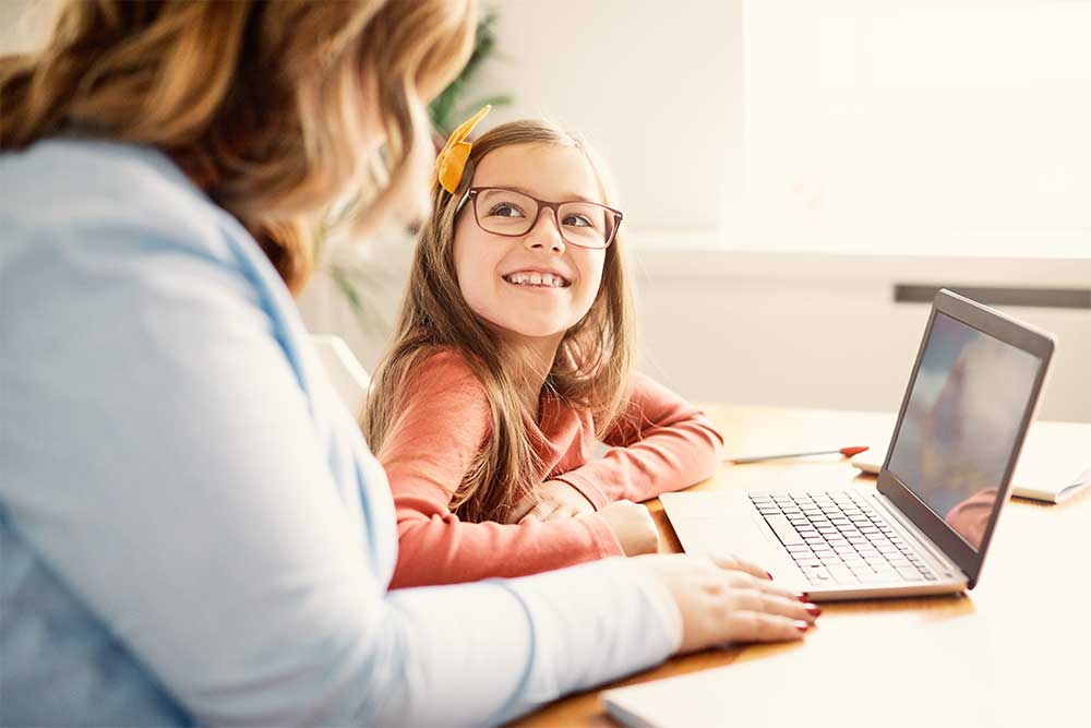 Parent working on laptop with student