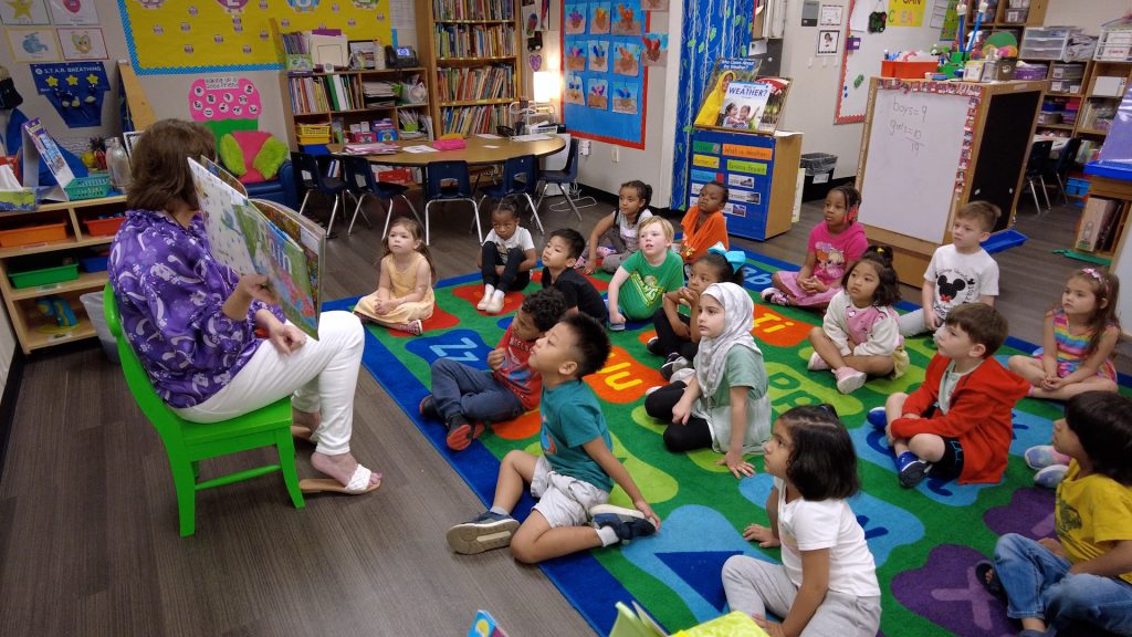 A teacher reads to an elementary classroom.