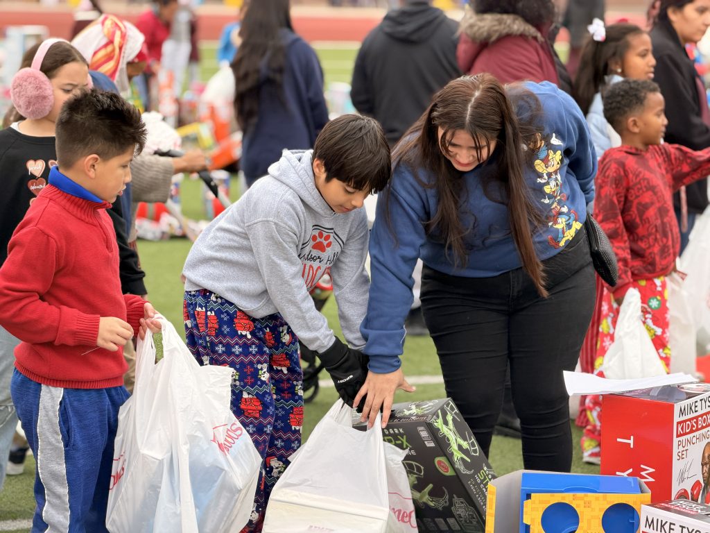 Student filling shopping bag with toys