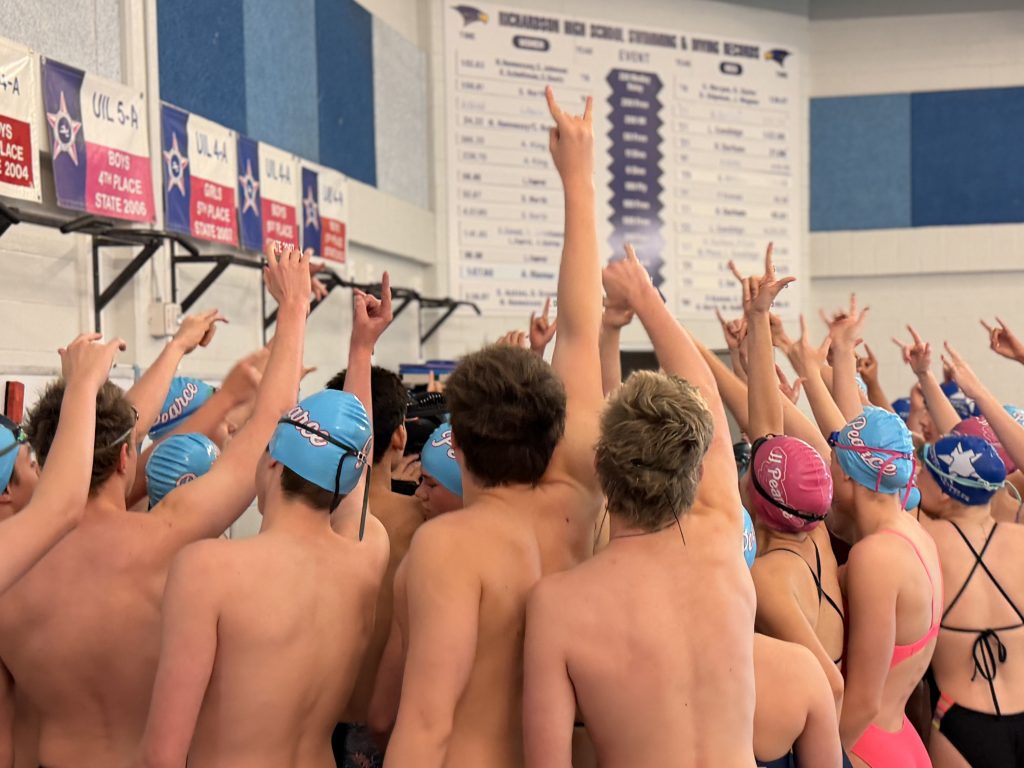 Swimmers holding hands up in celebration