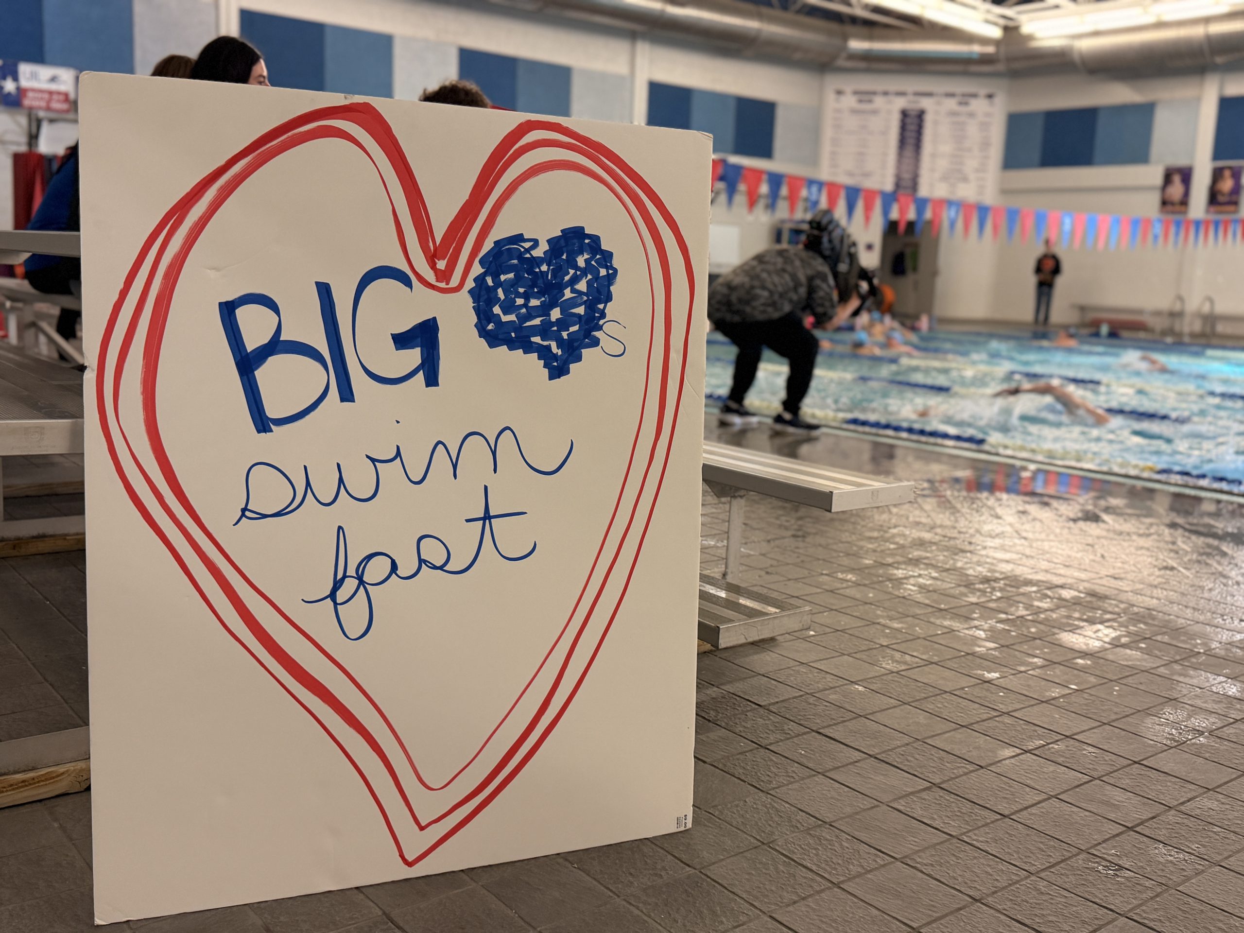 Big Heart Swim Fast posterboard in natatorium by the pool