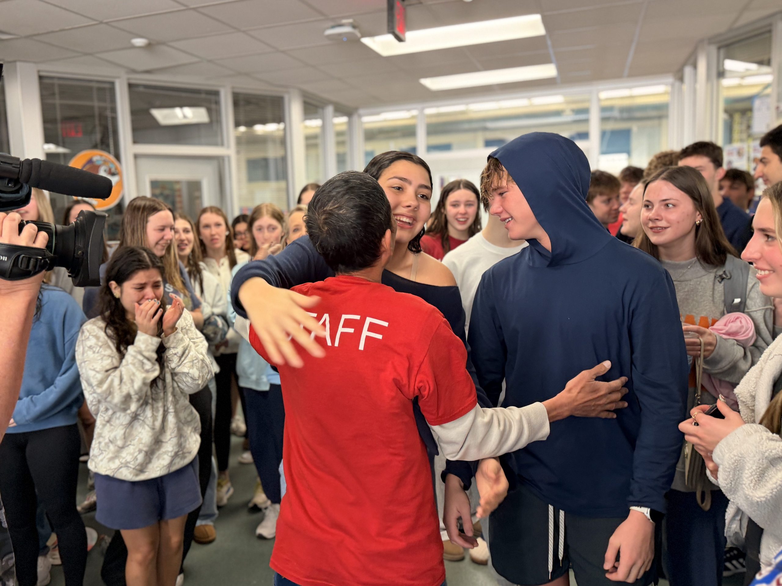 students embracing Mr. Le