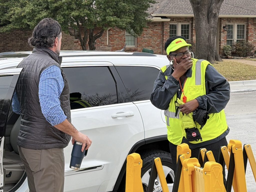 Ms. crawford holding mouth in surprise in front of car
