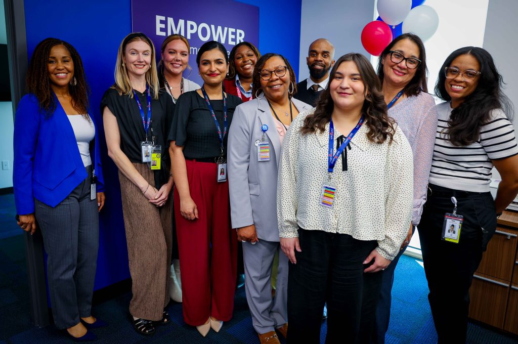 people posing in front of sign