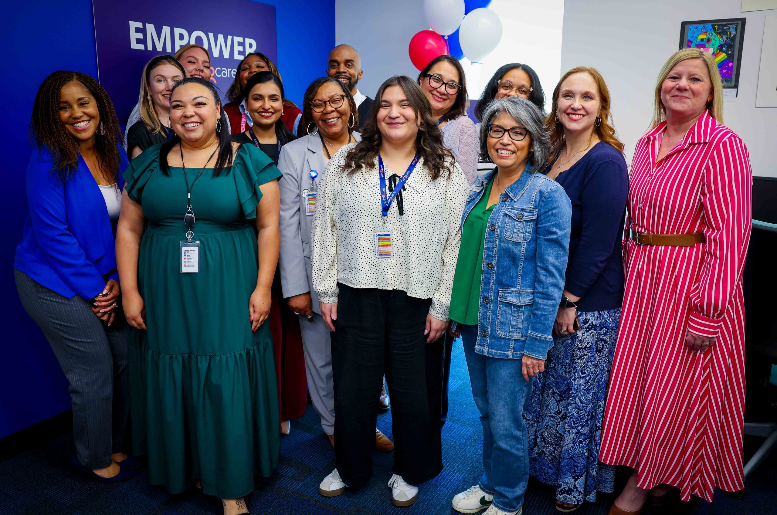 Group photo of RISD staff, board member, and metrocare staff at the new center in front of sign and balloons.
