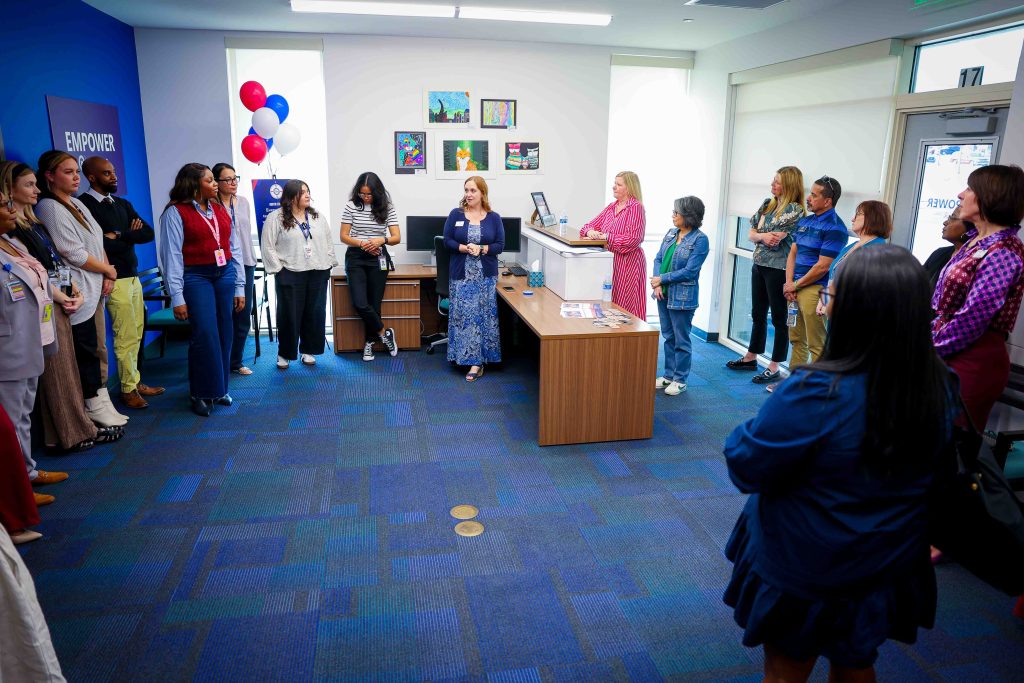 large group of people gathered around the room at the grand opepening