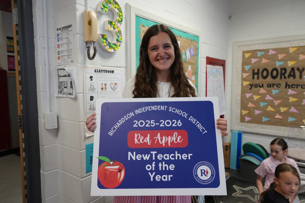 Elizabeth Richardson holding Red Apple New Teacher of the Year Poster