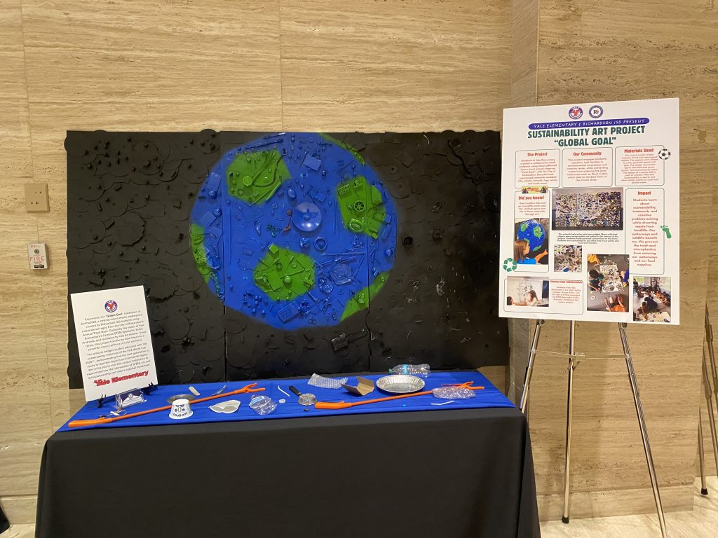 Global Goal Art piece on display with some found objects in front and information pieces on sides