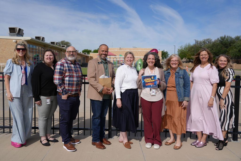 Super Teacher from Mohawk Elementary Beth Francis posing district and campus admin holding certificate and balloons on playground