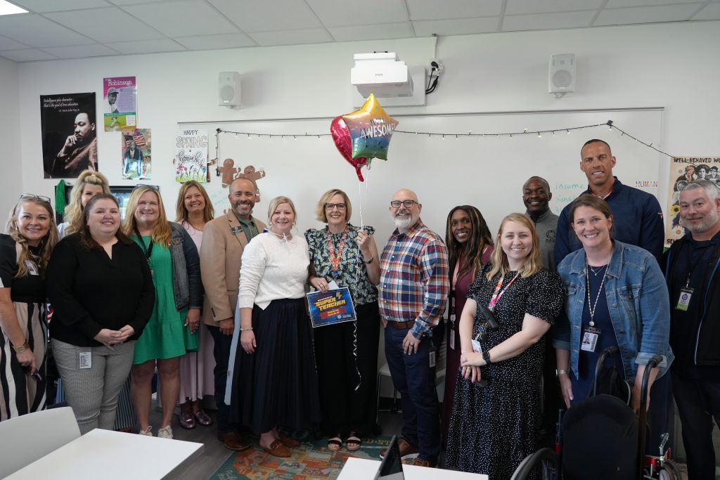 Super Teacher from Pearce HS Elizabeth Frith posing with district and campus admin holding certificate and balloons
