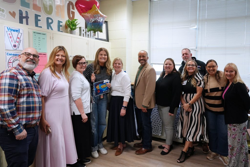 Super Teacher from Richardson Heights Elementary Reagan Fuller posing with students, district and campus admin holding certificate and balloons