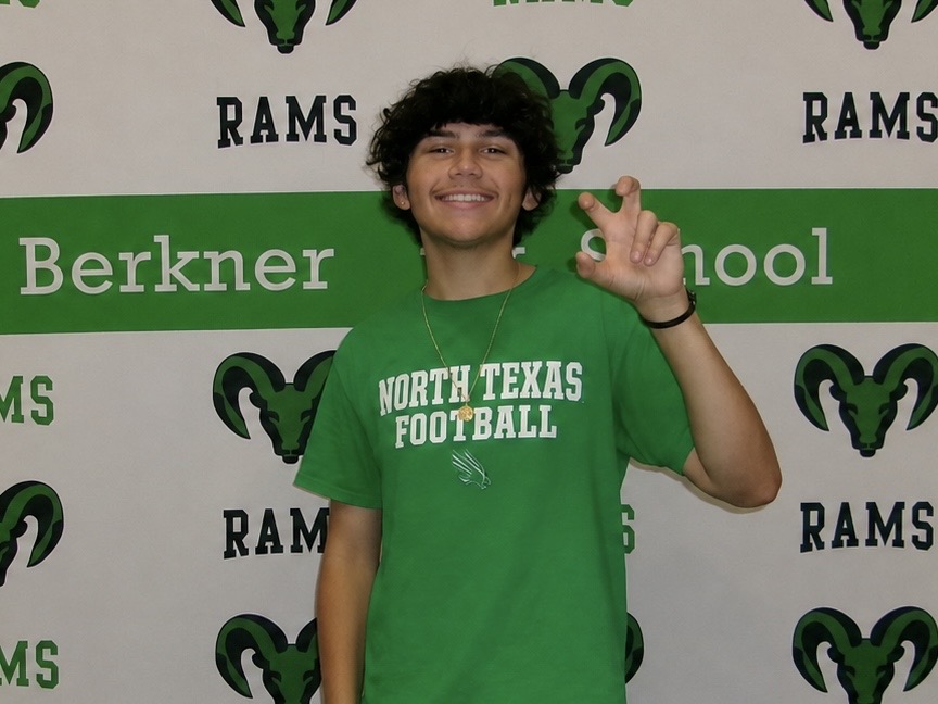 Isaiah in UNT Shirt in front of Berkner Rams backdrop