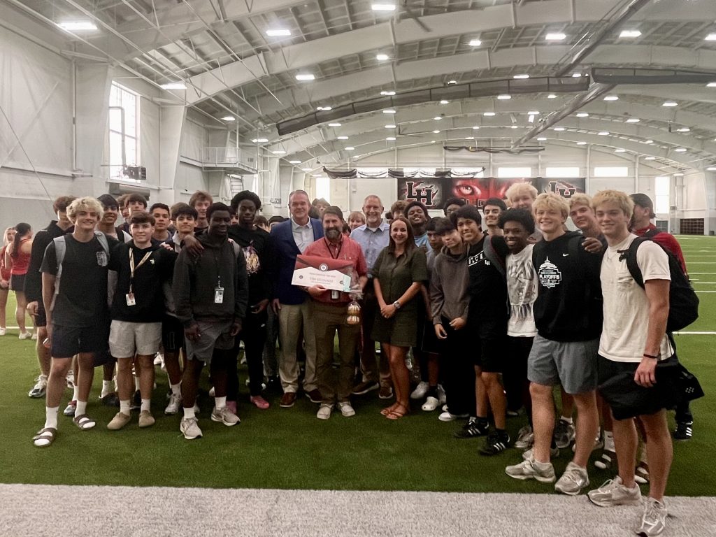 Coach Guinnee with students and award