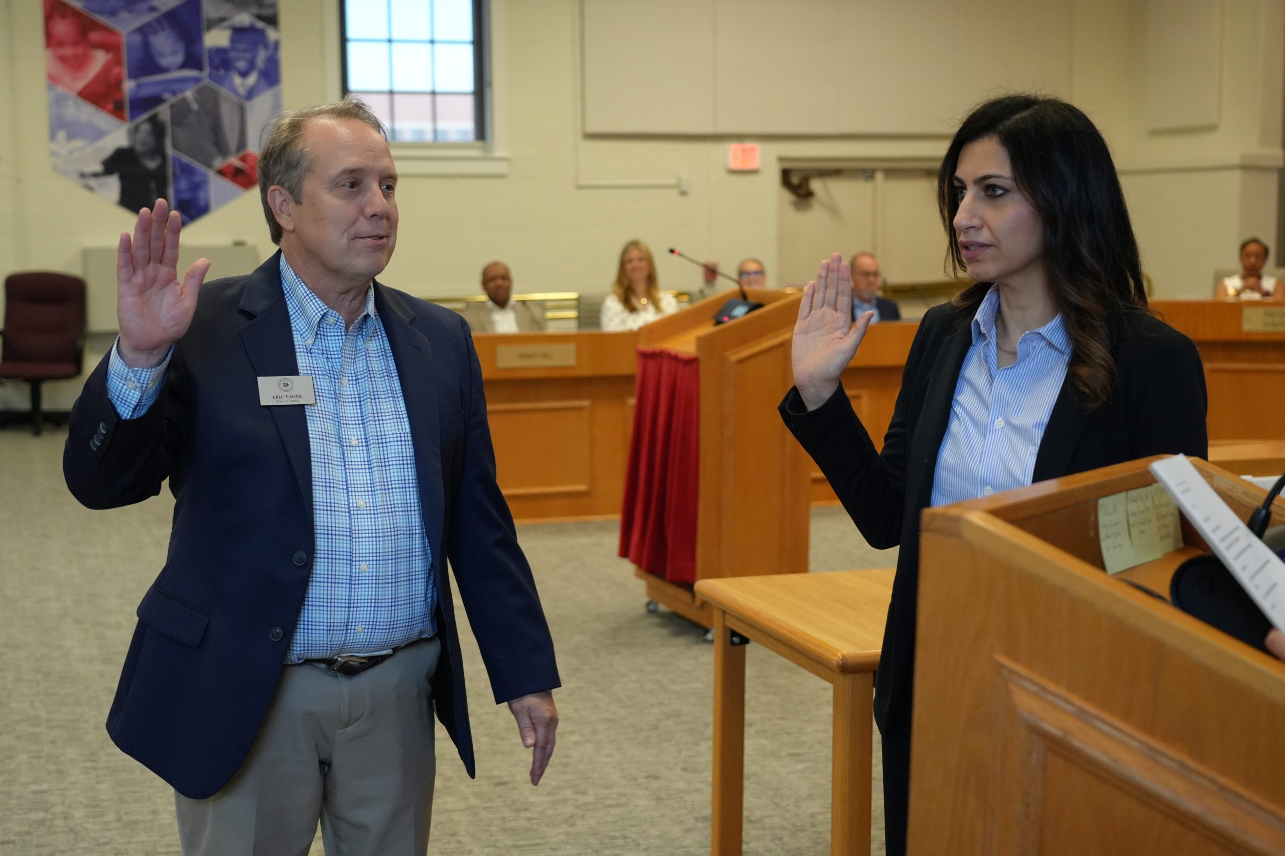 Trustees Eric Eager and Nazlee Burney holding up hands swearing in