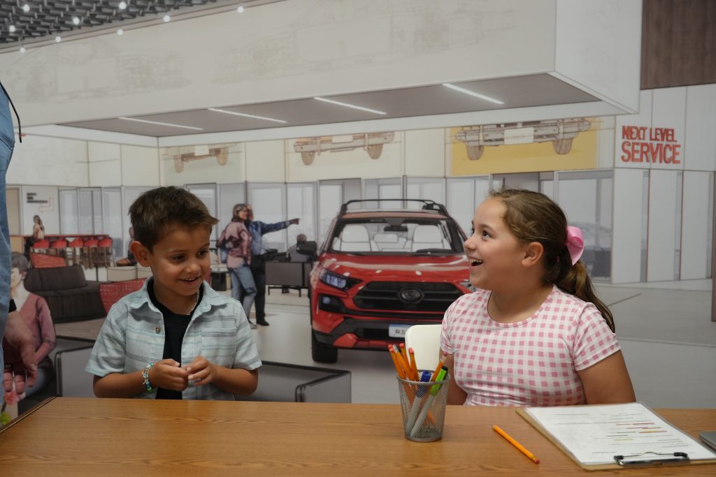 Kids smiling inside the Toyota Storefront
