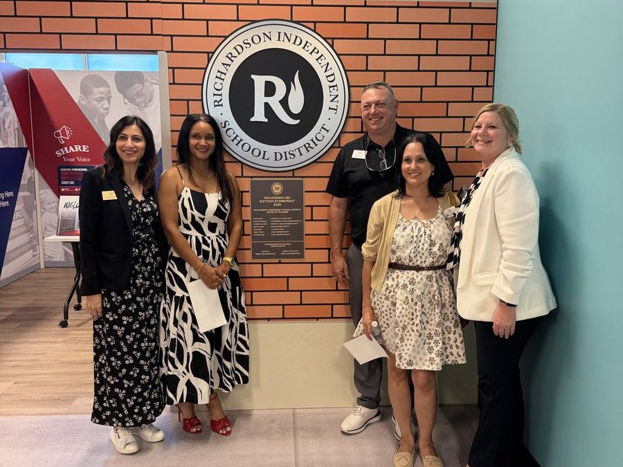Board members and superintendent standing in front of the Richardson ISD storefront