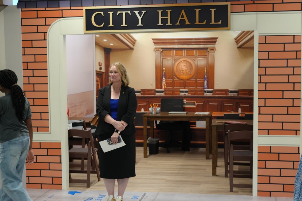 Woman standing in front of a City Hall storefront